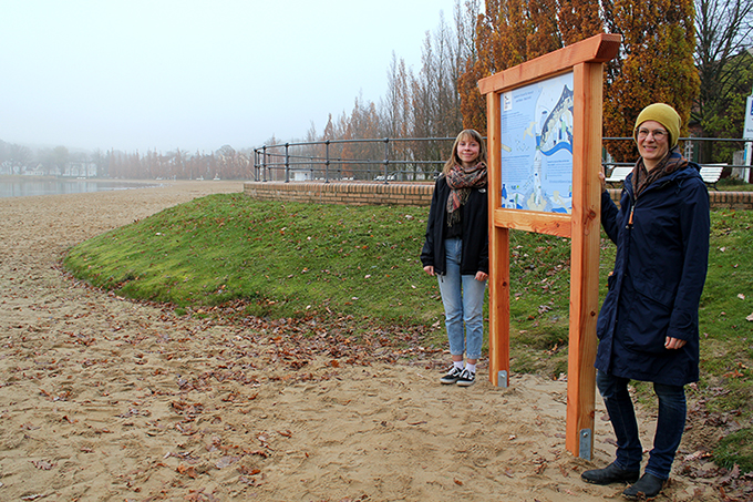 Melanie Frank (li.) und Eva Rieber freuen sich über den Aufbau der von ihnen konzipierten Infotafel am Zippendorfer Strand in Schwerin. Foto: Manuela Heberer